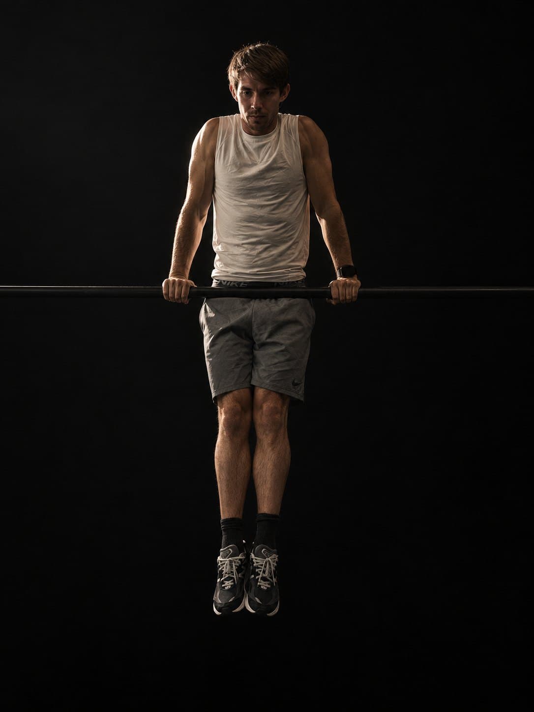 Clean muscle-up support — arms locked, body above the bar, dead-hang line below. The top of the pulling ladder.